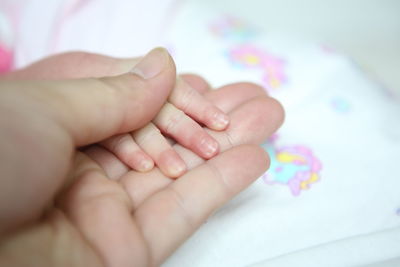 Close-up of baby hand on bed