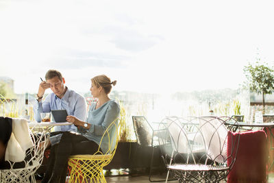 Business people working in cafe against clear sky