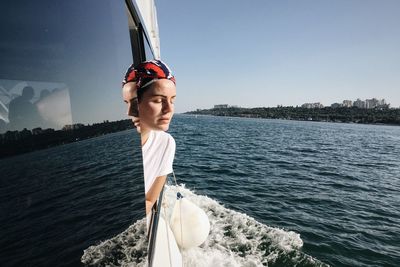 Portrait of young woman against clear sky