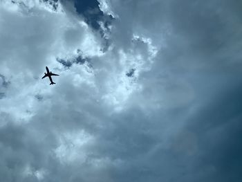 Low angle view of silhouette airplane flying in sky