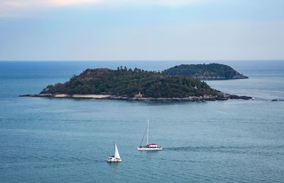 Sailboat sailing on sea against sky