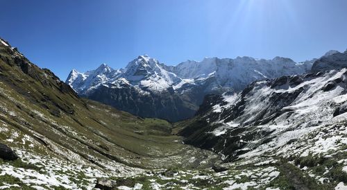 Scenic view of snowcapped mountains against clear blue sky