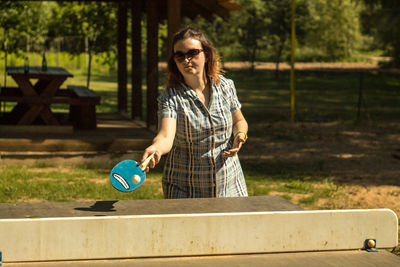 Mid adult woman playing table tennis at park