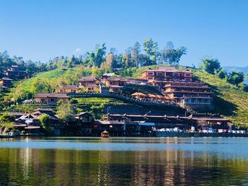 View of buildings by river against sky