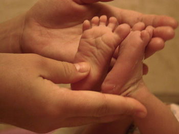 Close-up of father holding baby feet