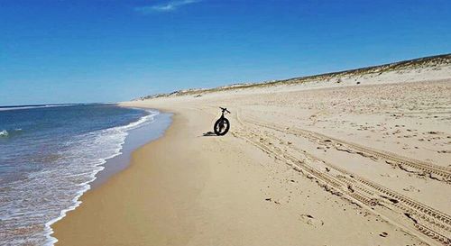 Man riding motorcycle on sand at beach