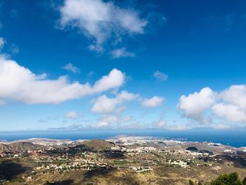 Aerial view of townscape against blue sky