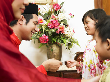 Father giving envelope to daughter at home