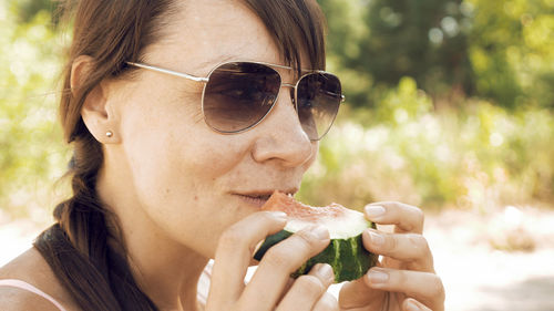 Close-up of woman eating watermelon at beach