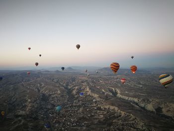 Hot air balloons flying over landscape