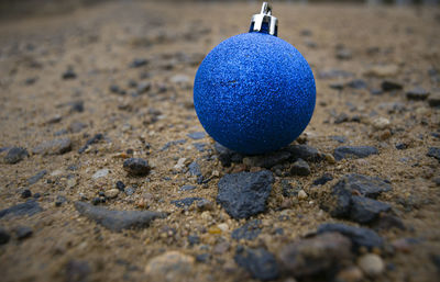 Close-up of blue ball on sand