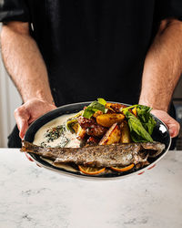 Midsection of man preparing food in plate