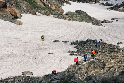 High angle view of people hiking on snowcapped mountain