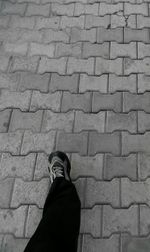 Low section of man standing on tiled floor