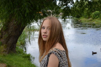 Portrait of woman with long hair by lake