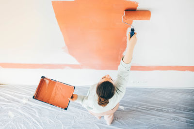 High angle view of woman painting wall