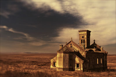 Old building on field against sky