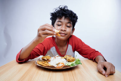 Portrait of young woman having food at home