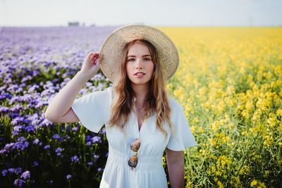 Portrait of beautiful young woman standing in field