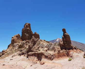 Rock formations against clear blue sky