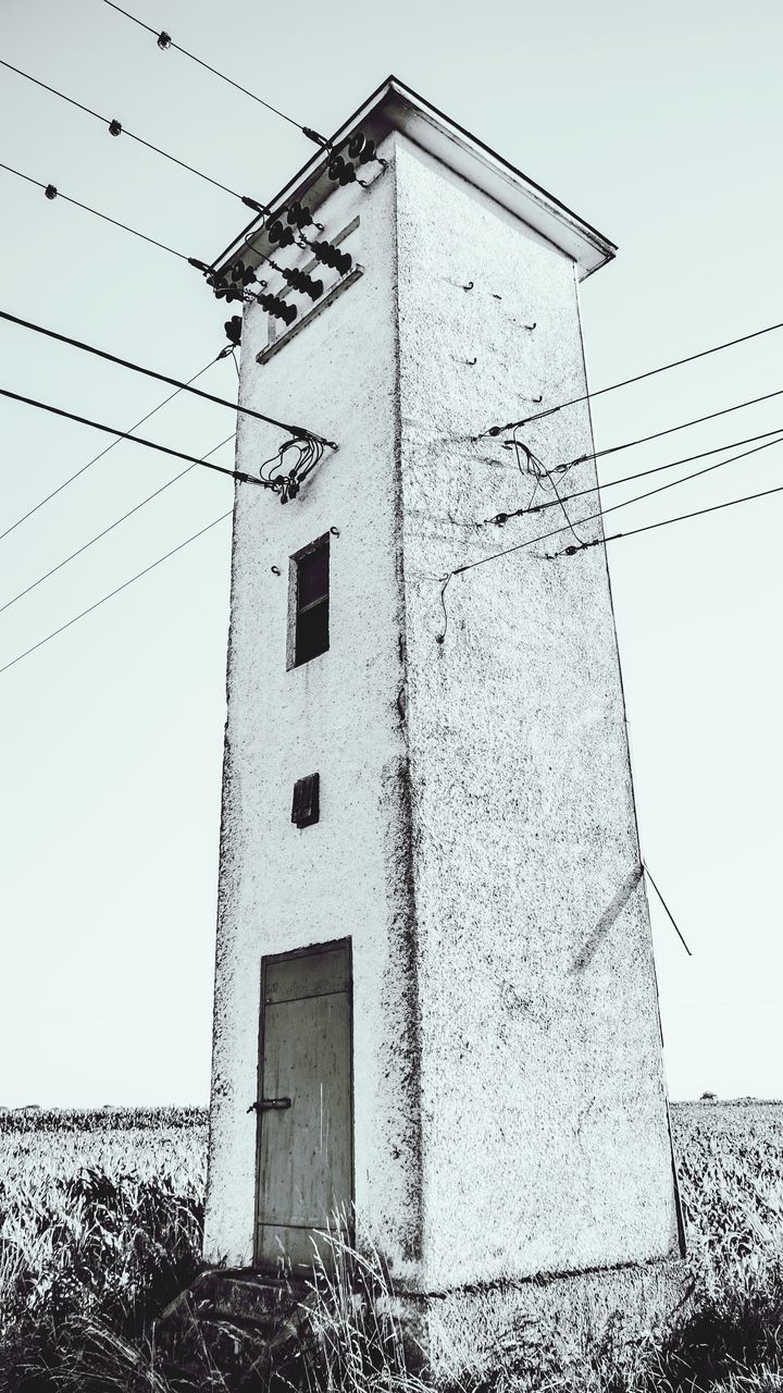 architecture, building exterior, built structure, low angle view, clear sky, power line, cable, building, window, day, residential structure, house, outdoors, residential building, sky, no people, wall - building feature, fuel and power generation, electricity, power supply