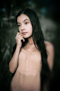 Portrait of beautiful woman standing against blurred background