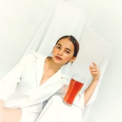 Portrait of beautiful young woman with drinking glass