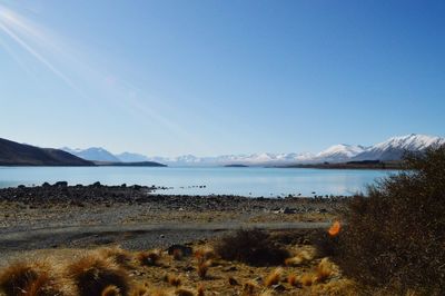 Scenic view of lake against clear blue sky