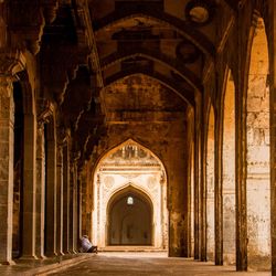 Man sitting at corridor of historic building