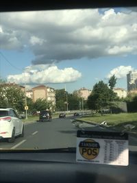 Cars on road against sky in city