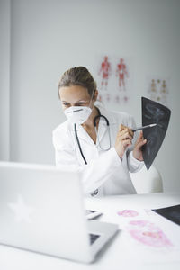 Woman using mobile phone while sitting on table