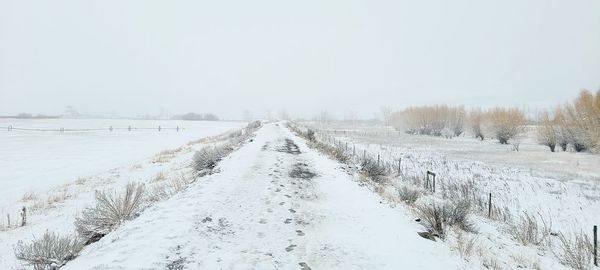 Scenic view of snow covered land against sky