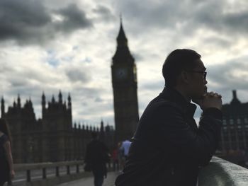 Side view of young man standing on westminster bridge