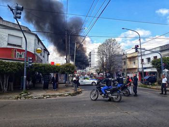 People on street in city against sky