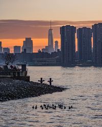 View of city at waterfront during sunset