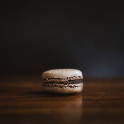 Close-up of fresh macaroon on table against wall