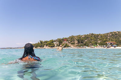 Happy young couple playing with a plastic disc in the sea. travel, vacation and fun