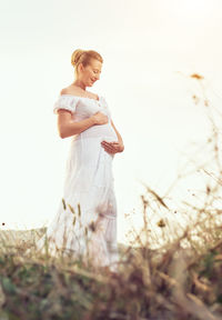 Woman standing on field against sky