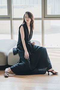 Portrait of woman sitting on floor at home