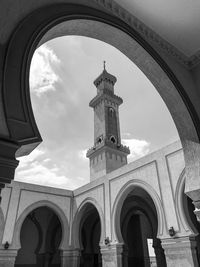 Low angle view of a minaret and a series of arches at a a mosque in new cairo