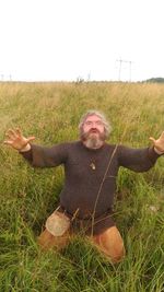 Portrait of man with arms raised on field