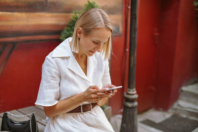 Woman looking away while using mobile phone