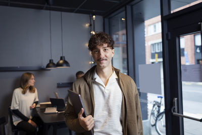 Smiling man in office looking at camera