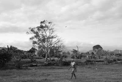 Scenic view of grassy field against cloudy sky