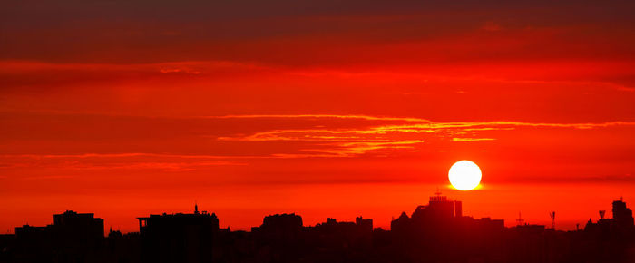 Panorama of silhouettes of buildings of the city of a red sunrise, red landscape of night kyiv.