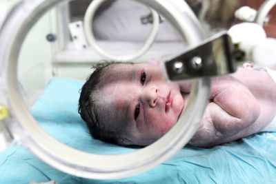 Portrait of cute baby girl lying on bed in hospital ward