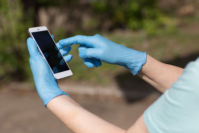 Midsection of person holding mobile phone