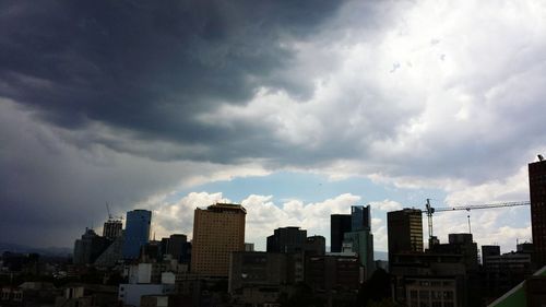 Buildings against cloudy sky