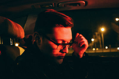 Portrait of man in illuminated car at night