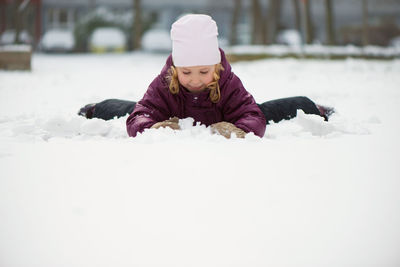 Cute girl playing with snow outdoors